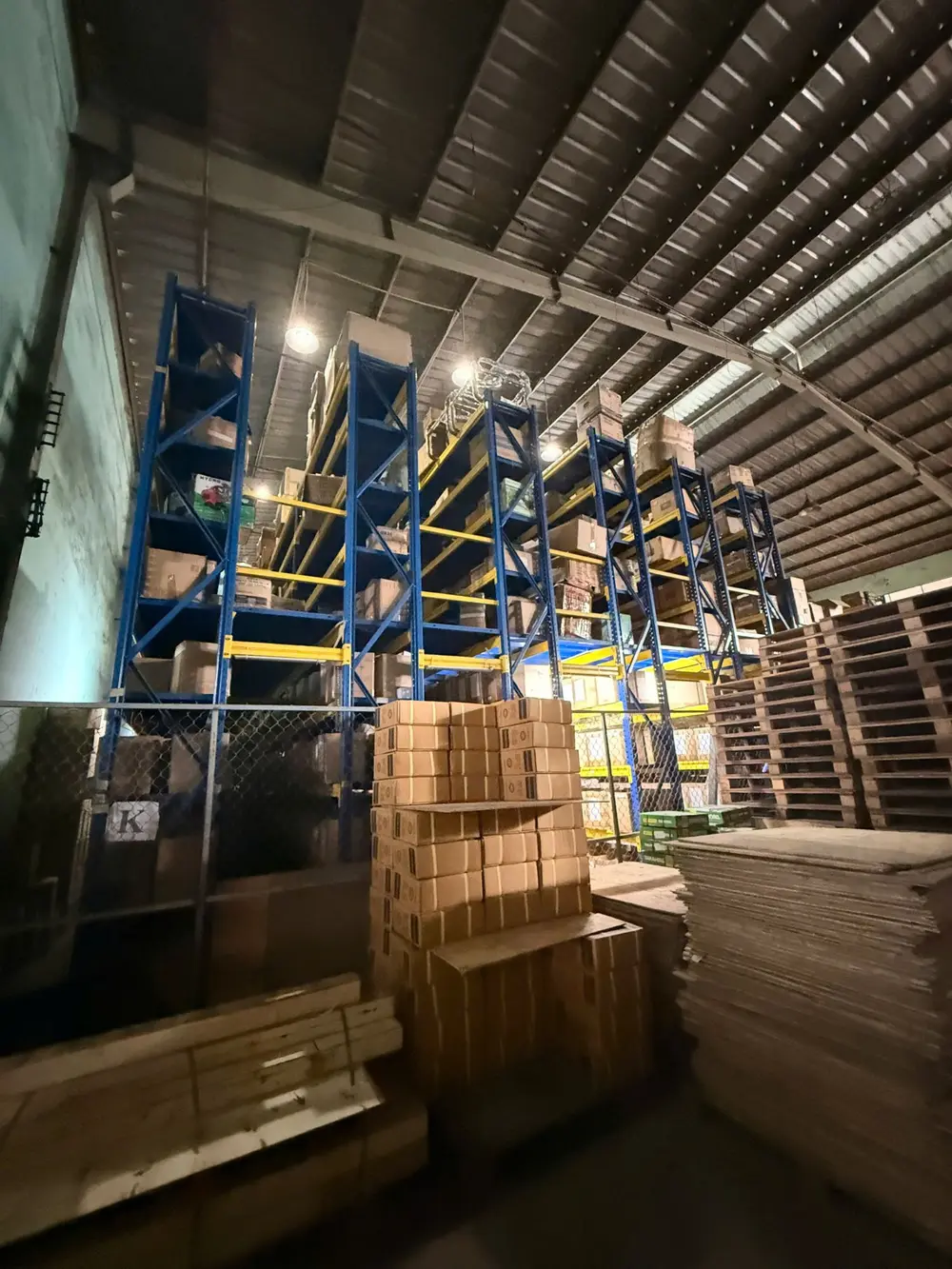 Hệ kệ thép xanh nhiều tầng chất thùng carton, pallet gỗ xếp chồng phía trước